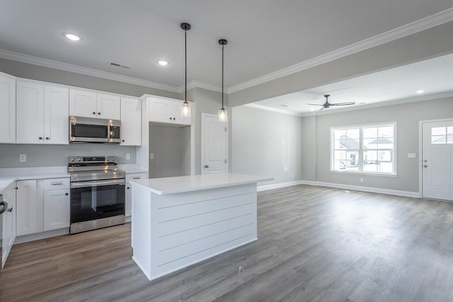 kitchen featuring white cabinets, a center island, ceiling fan, and appliances with stainless steel finishes