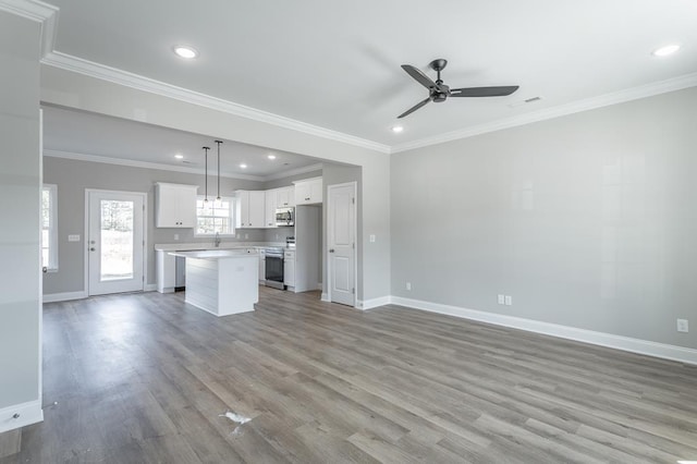 unfurnished living room with sink, ceiling fan, crown molding, and light wood-type flooring