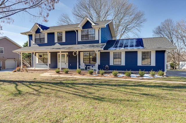 view of front of house featuring covered porch, a garage, and a front yard