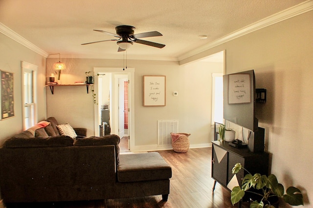 living room featuring ceiling fan, crown molding, and light hardwood / wood-style flooring