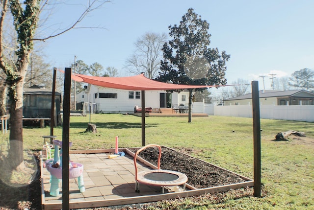 view of yard featuring a trampoline and a patio