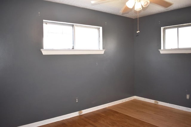 empty room featuring hardwood / wood-style flooring, a textured ceiling, and ceiling fan