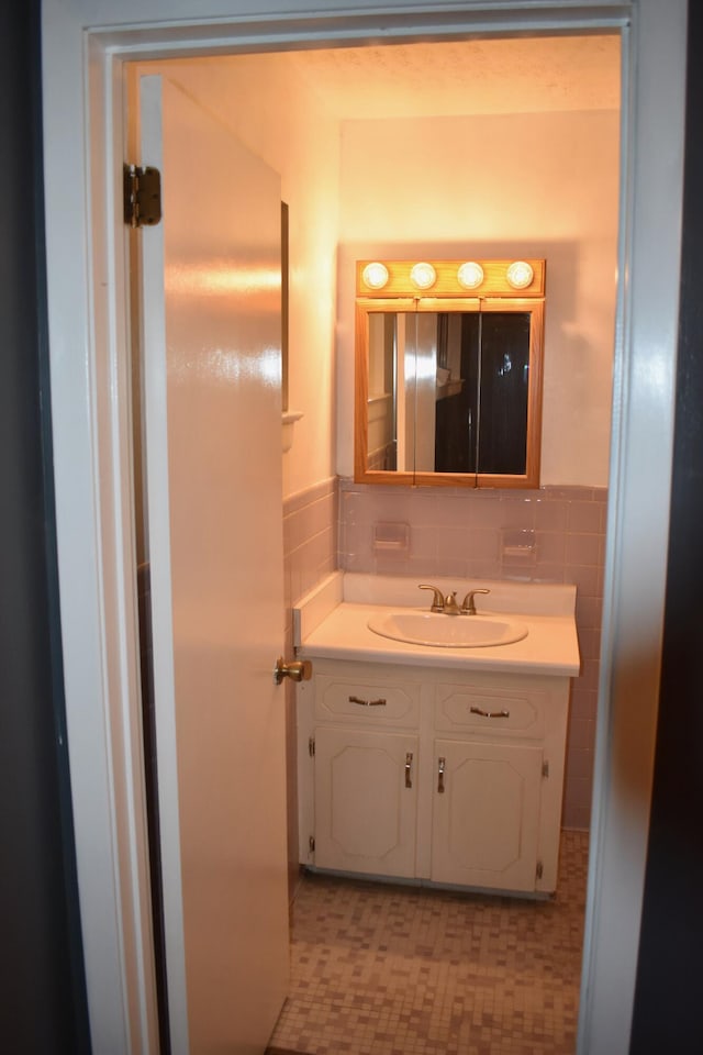 bathroom featuring tile walls and vanity