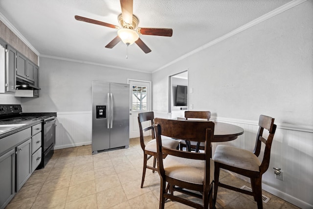 dining space featuring a textured ceiling, ceiling fan, and crown molding