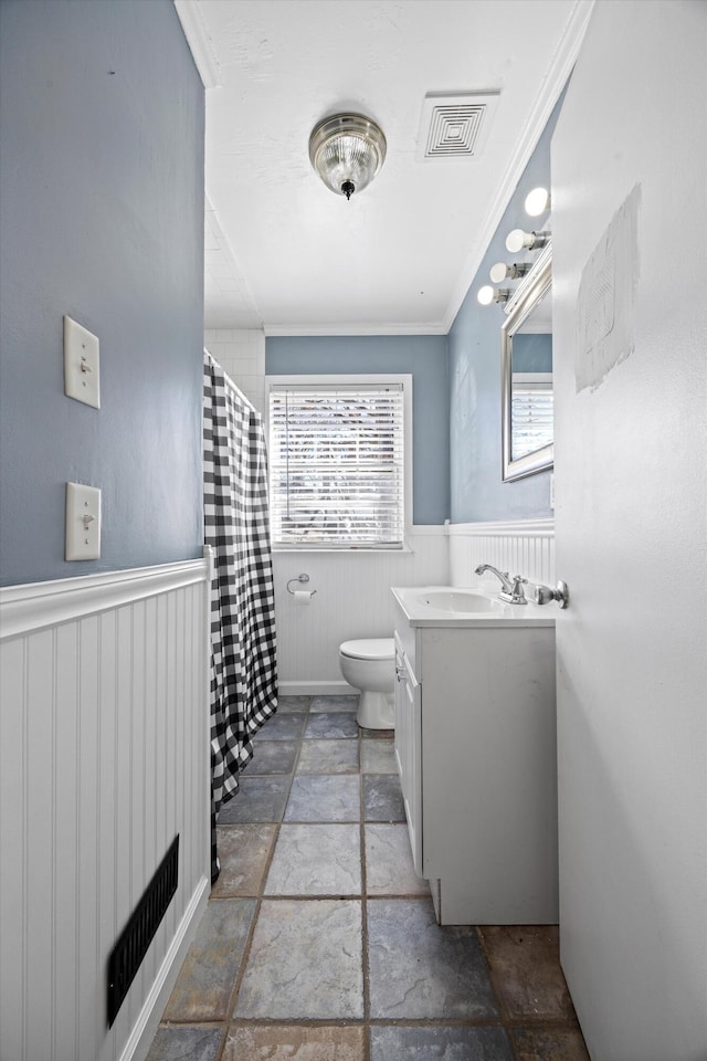 bathroom featuring toilet, crown molding, and vanity