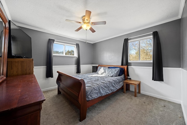 carpeted bedroom with ceiling fan, crown molding, and a textured ceiling