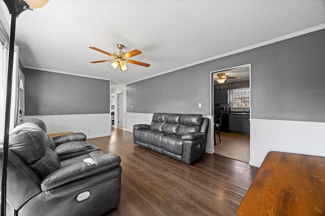 living room with ornamental molding, dark hardwood / wood-style flooring, a textured ceiling, and ceiling fan