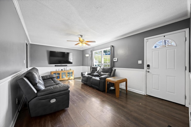 living room with a textured ceiling, ceiling fan, ornamental molding, and dark hardwood / wood-style flooring