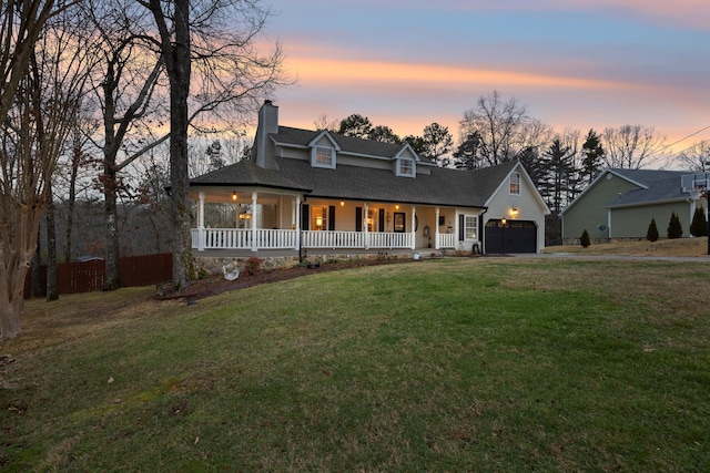 view of front of property with a porch, a lawn, and a garage