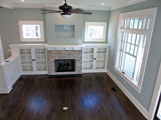 unfurnished living room featuring a healthy amount of sunlight, a brick fireplace, baseboards, and crown molding