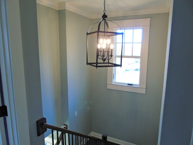 interior details with baseboards, ornamental molding, and an inviting chandelier