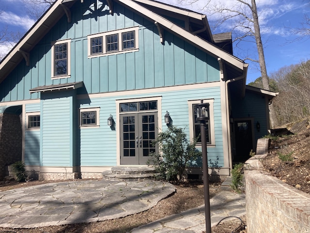 rear view of house featuring board and batten siding and french doors