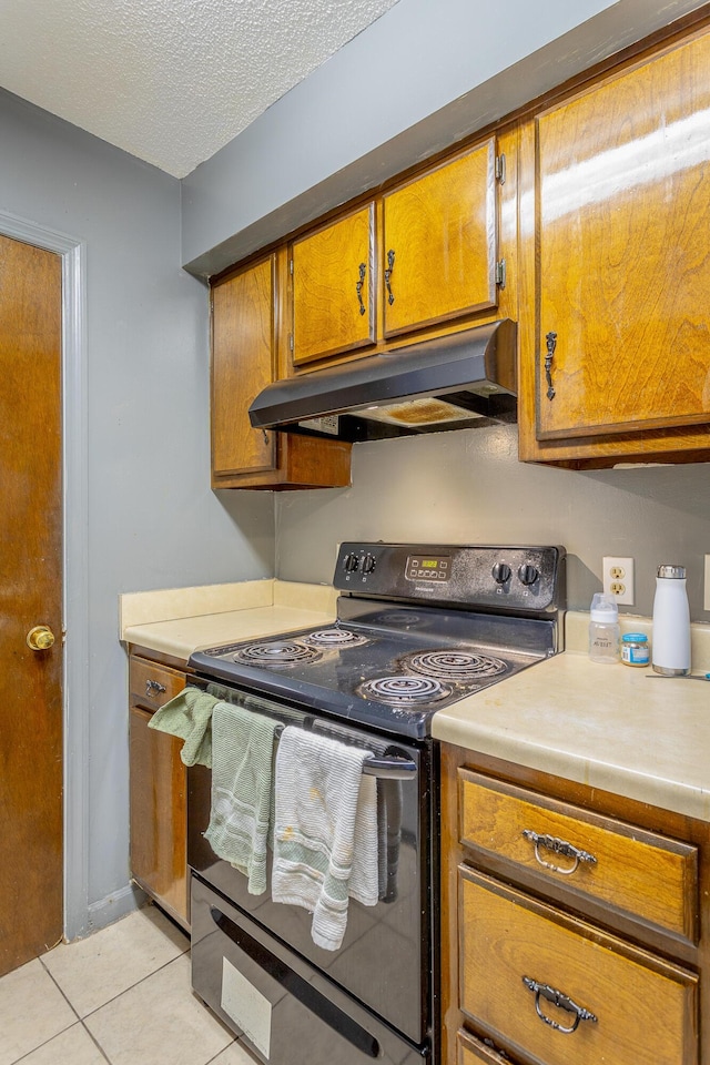 kitchen with a textured ceiling, light tile patterned floors, and black / electric stove