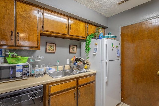 kitchen with sink, a textured ceiling, black dishwasher, and white fridge