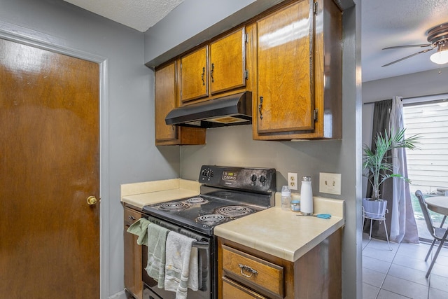 kitchen with ceiling fan, light tile patterned floors, black / electric stove, and a textured ceiling