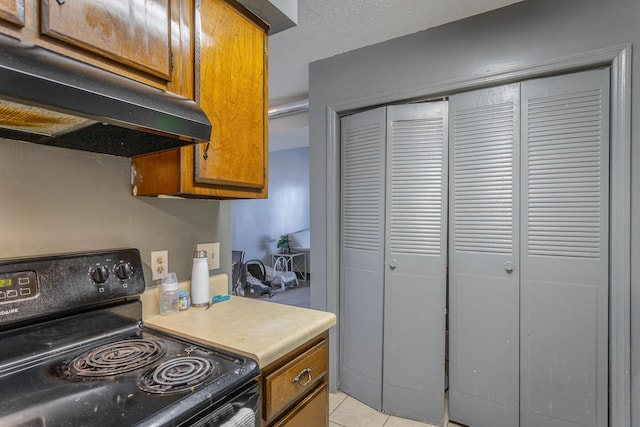 kitchen with a textured ceiling, light tile patterned flooring, and black range with electric stovetop