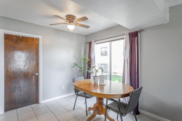 tiled dining room featuring ceiling fan, a healthy amount of sunlight, and a textured ceiling