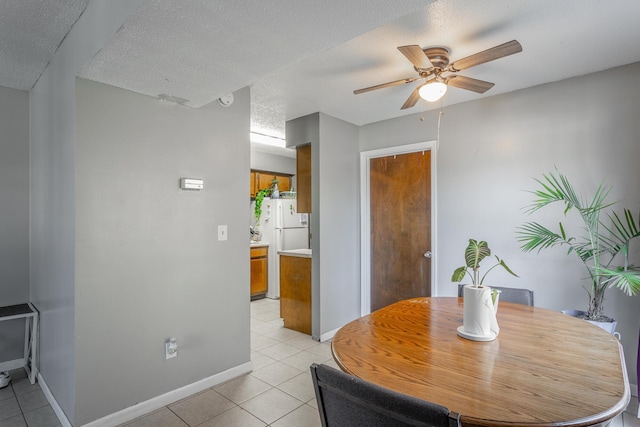 tiled dining room with ceiling fan and a textured ceiling