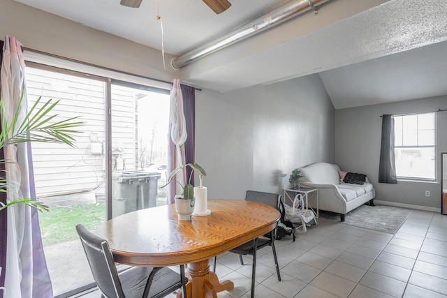 tiled dining room featuring vaulted ceiling and ceiling fan