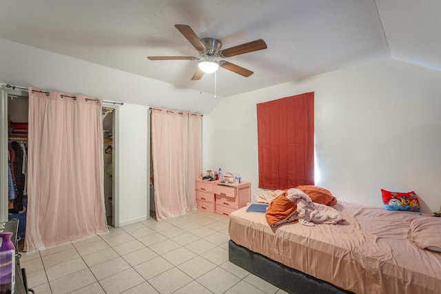 bedroom with ceiling fan, light tile patterned flooring, and vaulted ceiling