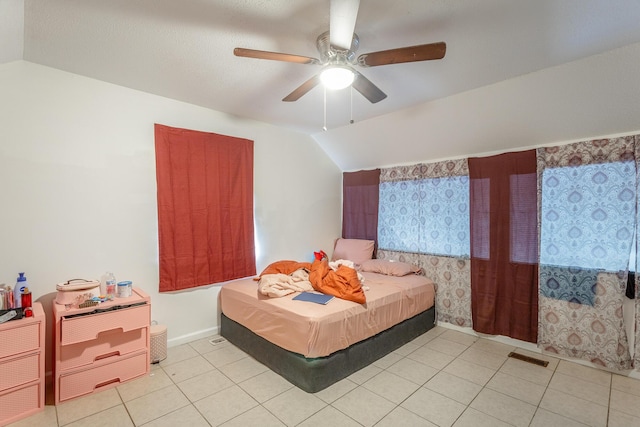 tiled bedroom with ceiling fan and lofted ceiling