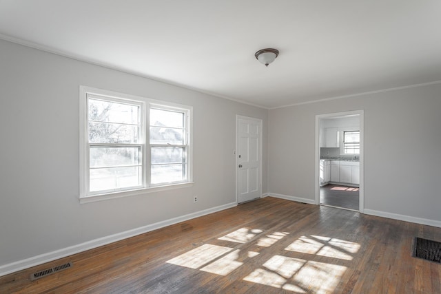 spare room with dark wood-type flooring and ornamental molding