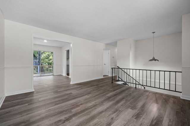 empty room featuring a textured ceiling and dark hardwood / wood-style flooring