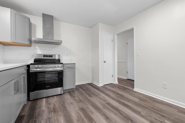 kitchen with dark hardwood / wood-style flooring, electric stove, gray cabinetry, and wall chimney range hood