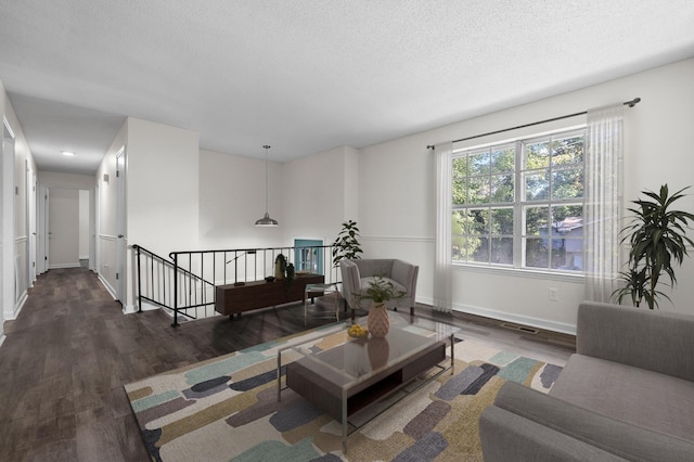 living room with dark hardwood / wood-style flooring and a textured ceiling