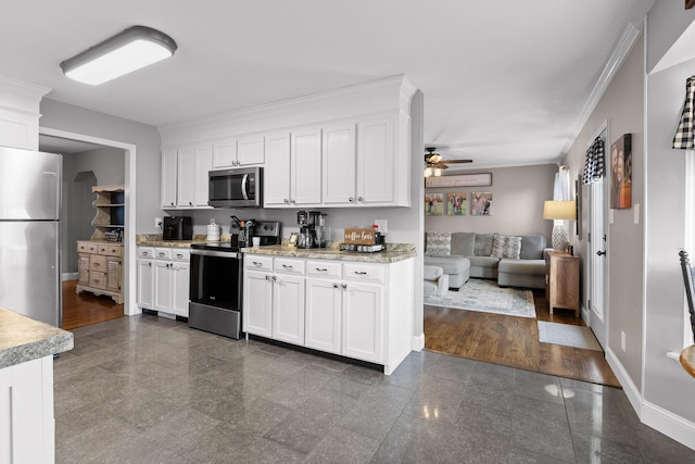 kitchen featuring appliances with stainless steel finishes, granite floors, ceiling fan, white cabinets, and baseboards