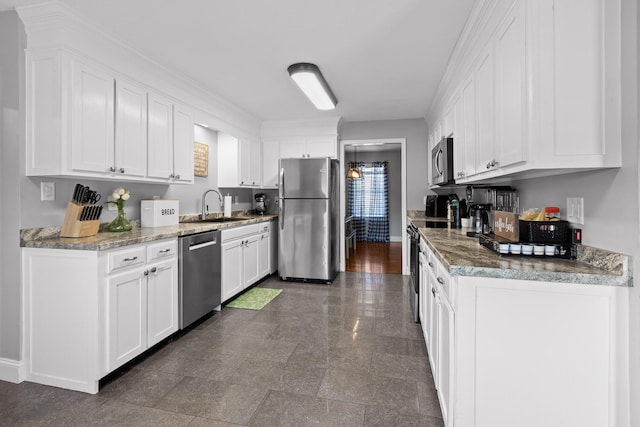 kitchen with appliances with stainless steel finishes, a sink, and white cabinets