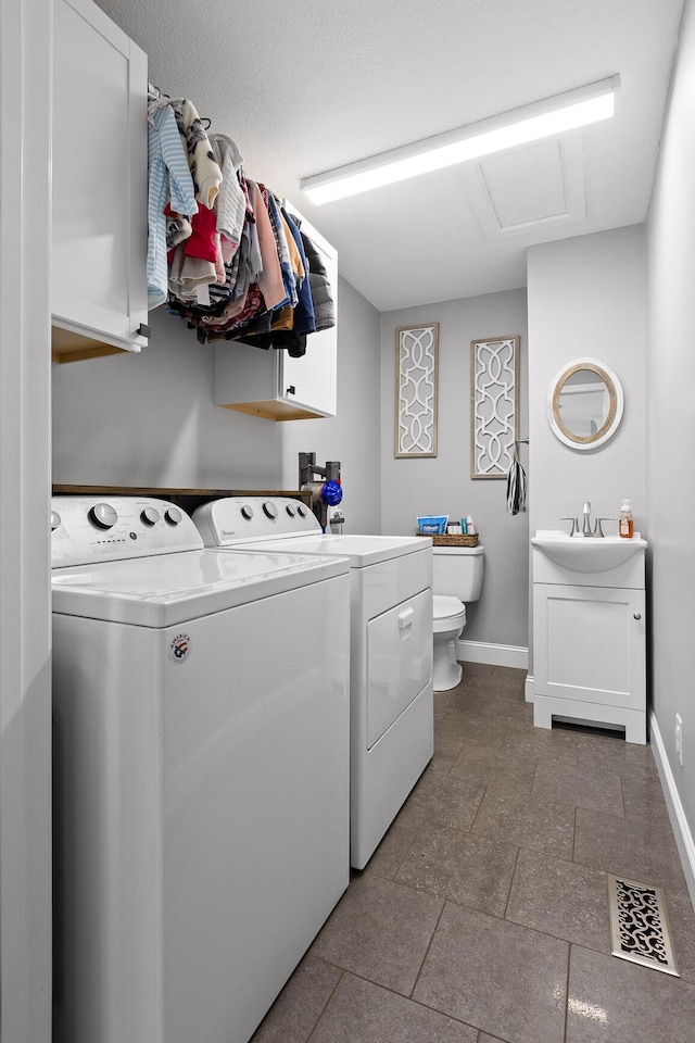 washroom with washing machine and clothes dryer, baseboards, attic access, and tile patterned flooring