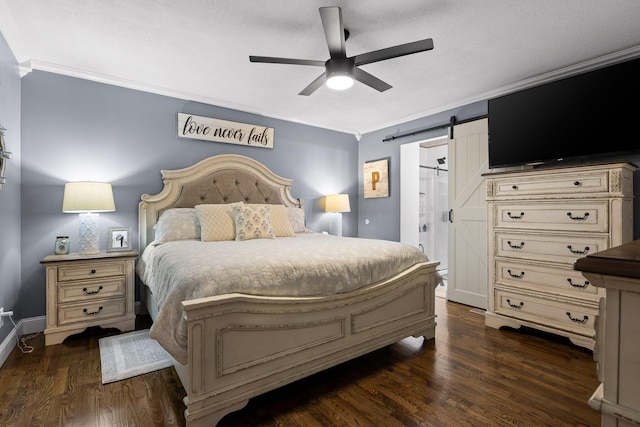 bedroom featuring ornamental molding, a barn door, dark wood-style flooring, a ceiling fan, and baseboards