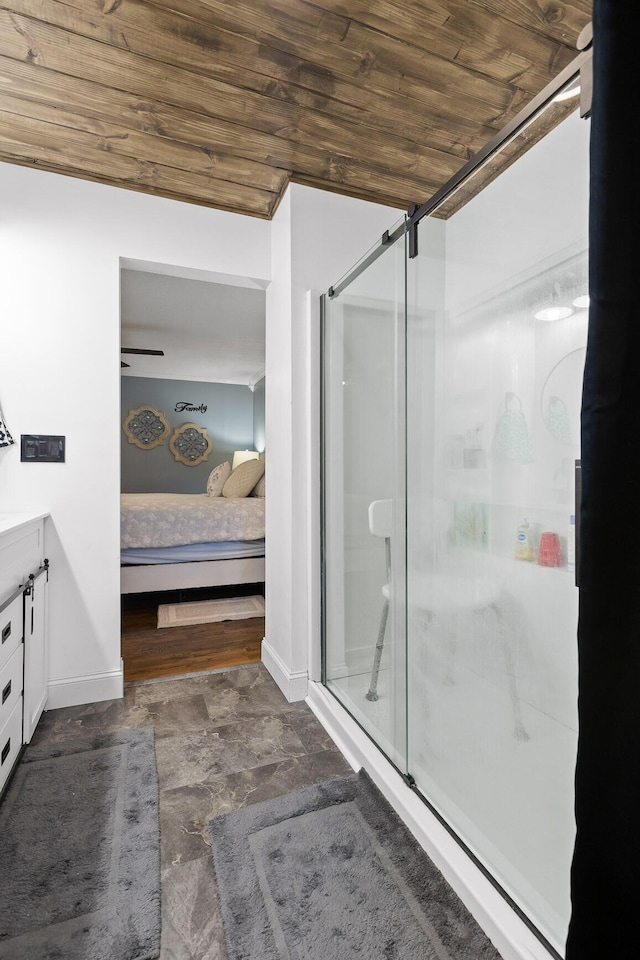 ensuite bathroom with wooden ceiling, a shower stall, vanity, and baseboards