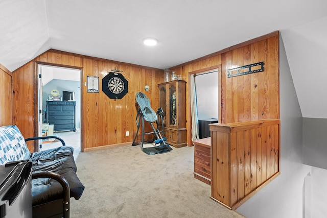workout room with wooden walls, lofted ceiling, carpet flooring, and baseboards