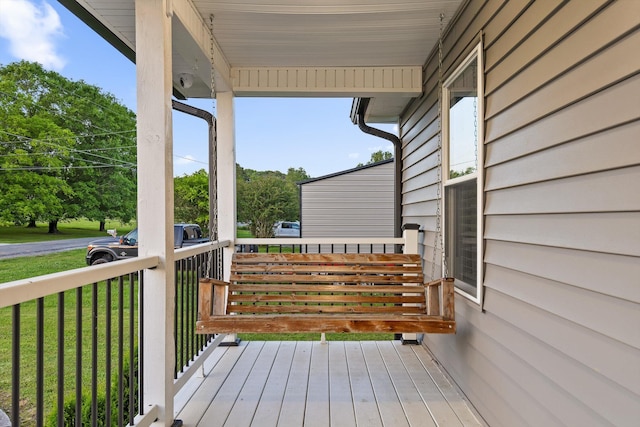 wooden terrace featuring a yard and covered porch