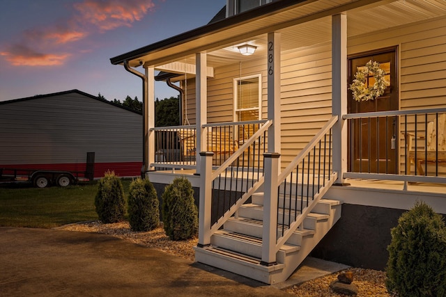 exterior entry at dusk featuring covered porch