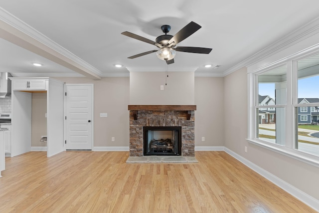 unfurnished living room with light hardwood / wood-style floors, ceiling fan, a stone fireplace, and crown molding