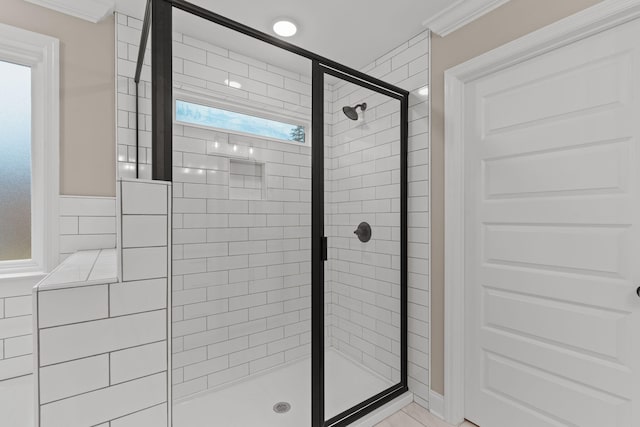 bathroom with an enclosed shower, tile patterned flooring, and crown molding