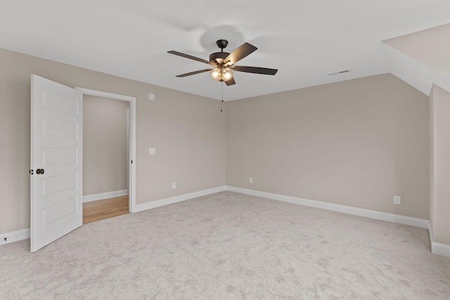 spare room with lofted ceiling, ceiling fan, and light carpet