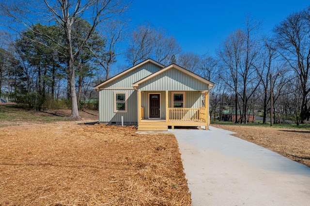 view of front of home featuring crawl space, board and batten siding, a porch, and driveway