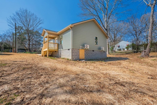 view of home's exterior with crawl space and stairway