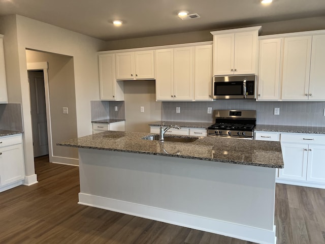 kitchen with white cabinets, a center island with sink, appliances with stainless steel finishes, and sink