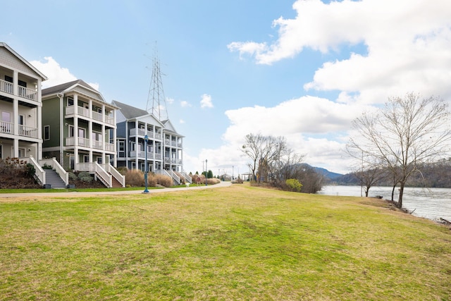 view of home's community featuring a water view and a yard