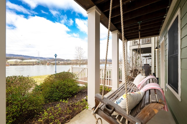 view of patio with covered porch and a water view