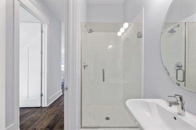 bathroom with sink, wood-type flooring, and a shower with door