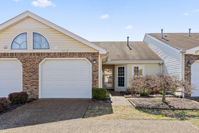 view of front of property with driveway, brick siding, and a shingled roof