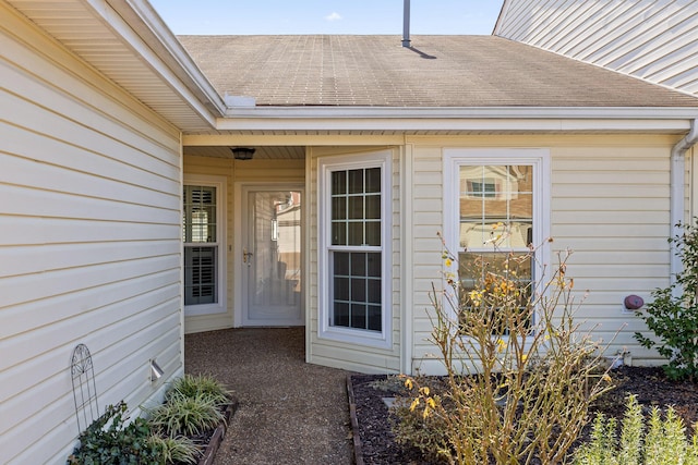 doorway to property featuring a shingled roof