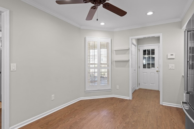 empty room with crown molding, baseboards, wood finished floors, and recessed lighting