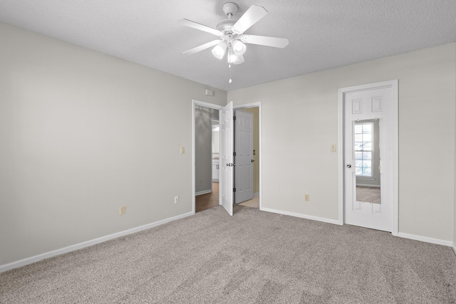 unfurnished bedroom with carpet floors, ceiling fan, baseboards, and a textured ceiling